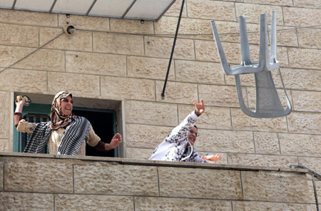 Arab protesters against Israel's decision to restrict entry into the Al-Aqsa Mosque, which is inside the holy site in the Old City, throw articles at Israeli policemen in the East Jerusalem neighborhood of Ras el- Amud on October 9, 2009.