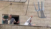 Arab protesters against Israel's decision to restrict entry into the Al-Aqsa Mosque, which is inside the holy site in the Old City, throw articles at Israeli policemen in the East Jerusalem neighborhood of Ras el- Amud on October 9, 2009.