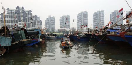 Fishing vessels return to the harbor of Sanya City, capital of south China's Hainan Province, October 11, 2009.