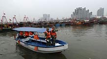 Police in Sanya patrol near the harbor of Sanya City, capital of south China's Hainan Province, October 11, 2009.