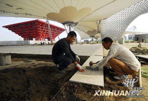 Workers lay paving for the Expo Boulevard at the World Expo Site in Shanghai on October 10, 2009. 