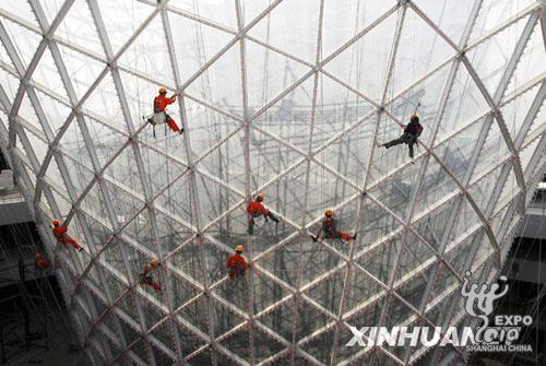 Chinese workers work on the horn-shaped 'Sunny Valley' building which lines the Expo Boulevard at the World Expo site in Shanghai on October 10, 2009. The construction of the Expo Boulevard, a large, integrated commercial and traffic complex, has entered the stage of 'fine decoration.' 