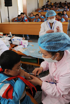 A pupil is injected the vaccine against the A/H1N1 flu in Lhasa, capital of southwest China's Tibet Autonomous Region, October 14, 2009.