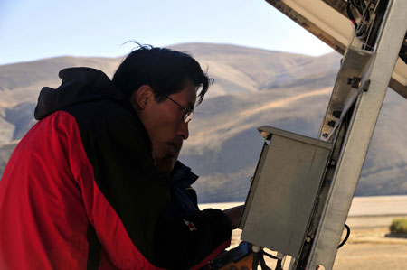 A technician debugs devices at the unmanned earthquake monitor in Tingri County, southwest China's Tibet Autonomous Region, October 17, 2009. China's first unmanned earthquake monitor has been established and put into use at 4255 meters above sea level on Mt. Qomolangma.