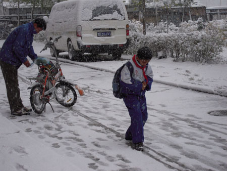 A boy walks in the snow in Qiqihar City, northeast China's Heilongjiang Province, October 19, 2009.