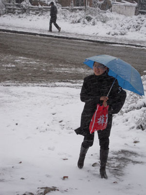 A woman walks in the snow in Qiqihar City, northeast China's Heilongjiang Province, October 19, 2009.