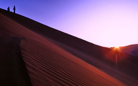 Tourists view sunrise in Badain Jaran Desert located in Araxan League of north China's Inner Mongolia Autonomous Region, October 17, 2009.