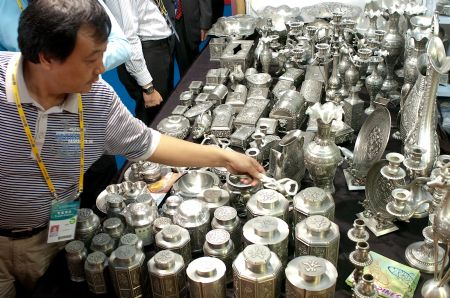 A visitor chooses tin wares from the Philippines at the 6th China-ASEAN Exposition (CAEXPO) in Nanning, capital of southwest China's Guangxi Zhuang Autonomous Region, on October 20, 2009.