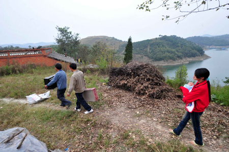 Resettlers displaced by the North-to-South Water Diversion Project from Xijiadian Township, Danjiangkou City of northwest China's Hubei Province, carry furnitures to their new houses at the Yepo settlement, Jingmen city of Hubei Province, October 19, 2009. The 4th batch of 94 families of resettlers from Xijiadian Township moved into their new houses in Jingmen on Tuesday. 