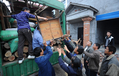 Resettlers displaced by the North-to-South Water Diversion Project from Xijiadian Township, Danjiangkou City of northwest China's Hubei Province, carry furnitures to their new houses at the Yepo settlement, Jingmen city of Hubei Province, October 20, 2009. The 4th batch of 94 families of resettlers from Xijiadian Township moved into their new houses in Jingmen on Tuesday. 