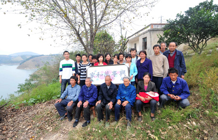 Resettlers pose for photos before displaced by the North-to-South Water Diversion Project in Xijiadian Township, Danjiangkou City of northwest China's Hubei Province, October 18, 2009. The 4th batch of 94 families of resettlers from Xijiadian Township moved into their new houses in Jingmen on Tuesday.