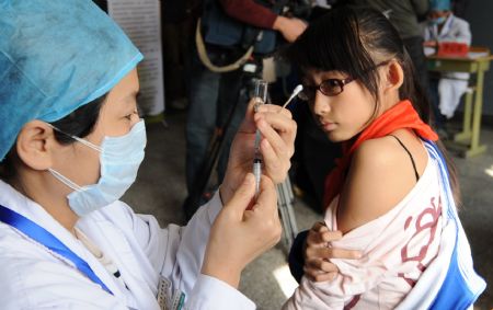 A student receives A/H1N1 flu vaccine injection at Chuiyangliu middle school in Beijing, capital of China, October 21, 2009. 