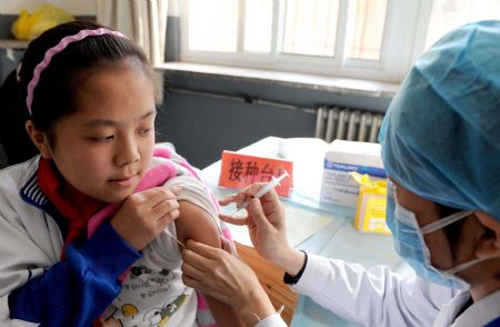 A student receives A/H1N1 flu vaccine injection at Chuiyangliu middle school in Beijing, capital of China, October 21, 2009.