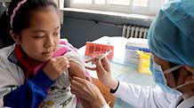 A student receives A/H1N1 flu vaccine injection at Chuiyangliu middle school in Beijing, capital of China, October 21, 2009.