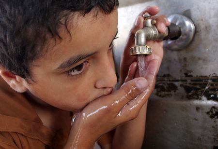 A Palestinian boy drinks water in the southern Gaza Strip town of Rafah October 21, 2009. 