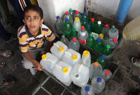 A Palestinian boy fetches drinking water with plastic bottles in the southern Gaza Strip town of Rafah October 21, 2009.