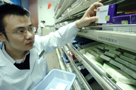 An apothecary takes medicines for patients in the provincial hospital in Hefei, east China's Anhui Province, October 22, 2009.