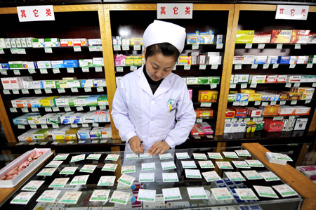 A woman updates the price of medicine in a drug store in Yinchuan, northwest China's Ningxia Hui Autonomous Region, October 22, 2009. 