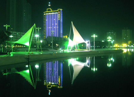 Photo taken on October 15, 2009 shows the night scene of the Konqi River in Korla, capital of Mongolian Autonomous Prefecture of Bayingolin, northwest China's Xinjiang Uygur Autonomous Region. Located on the northeast edge of the Tarim Basin, Korla is known for its production of fragrant pears, oil and natural gas.