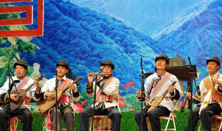 Performers of Lisu ethnic group play folk musical instruments during a show in Lisu Autonomous County of Weixi, southwest China's Yunnan Province, on October 22, 2009. 