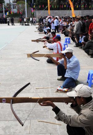 Men of Lisu ethnic group compete in a bowing contest in Lisu Autonomous County of Weixi, southwest China's Yunnan Province, on October 22, 2009. 