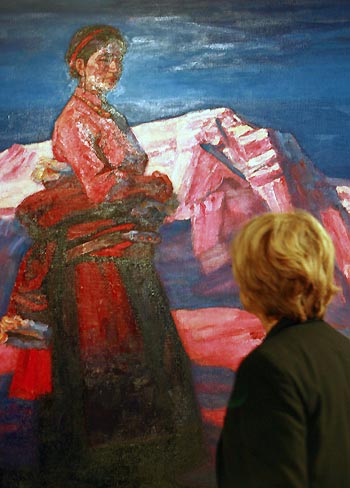 A visitor looks at a picture on display at an exhibition of paintings by Han and Tibetan artists in Rome, capital of Italy, October 23, 2009. 