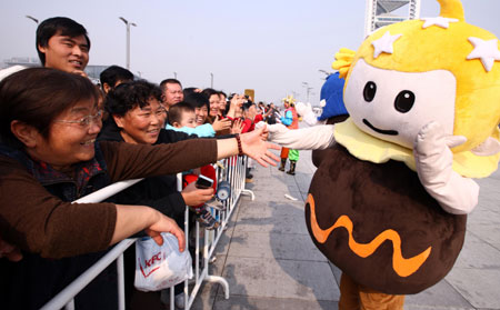 A performer dressed as the mascot of the Tourism Festival interacts with visitors during a parade at the Olympic Park in Beijing, capital of China, on October 23, 2009. 