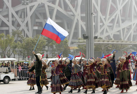 Performers from Russia wave to visitors during a parade at the Olympic Park in Beijing, capital of China, on October 23, 2009. 