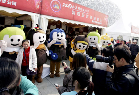 Visitors take photos of mascots of the Tourism Festival at the Olympic Park in Beijing, capital of China, on October 23, 2009. 