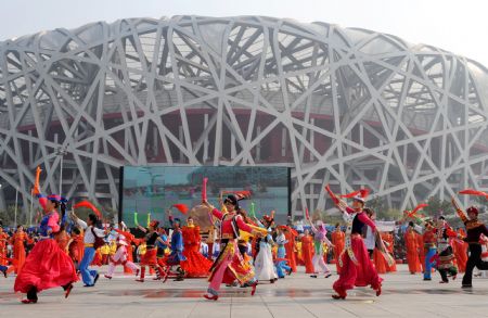 Performers dance during a parade at the Olympic Park in Beijing, capital of China, on Oct. 23, 2009. The 11th Beijing International Tourism Festival opening here on Friday brought together about 3000 performers from 71 countries and regions, as well as 18 disctricts and counties of Beijing.