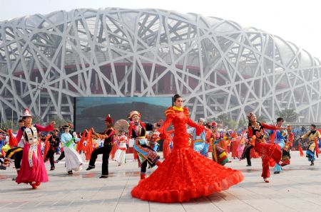 Performers dance during a parade at the Olympic Park in Beijing, capital of China, on Oct. 23, 2009. The 11th Beijing International Tourism Festival opening here on Friday brought together about 3000 performers from 71 countries and regions, as well as 18 disctricts and counties of Beijing.