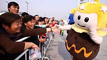 A performer dressed as the mascot of the Tourism Festival interacts with visitors during a parade at the Olympic Park in Beijing, capital of China, on October 23, 2009.
