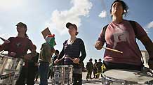 International peace activists play drums in front of Israeli soldiers during in a demonstration against Israel's construction of a separation barrier in the West Bank village of Al-Maasara near Bethlehem, October 23, 2009.