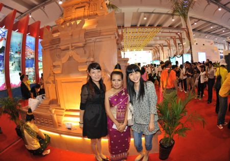 Local residents pose for photos with an actor at Laos Pavilion in the Nanning International Convention and Exhibition Center, which is the venue of the 6th China-ASEAN Expo, in Nanning, capital of southwest China's Guangxi Zhuang Autonomous Region, October 24, 2009. 