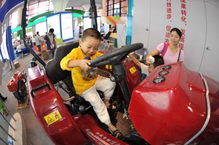 A child plays on an agricultural machine at the Nanning International Convention and Exhibition Center, which is the venue of the 6th China-ASEAN Expo, in Nanning, capital of southwest China's Guangxi Zhuang Autonomous Region, October 24, 2009.