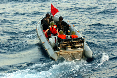 Chinese navy special forces members of &apos;Zhoushan&apos; missile frigate prepare to patrol by a speed boat at sea, October 23, 2009. 