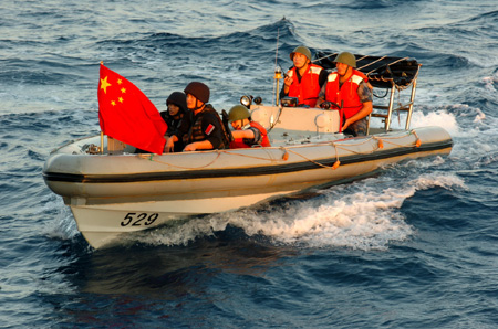 Chinese navy special forces members of &apos;Zhoushan&apos; missile frigate prepare to patrol by a speed boat at sea, October 23, 2009. 