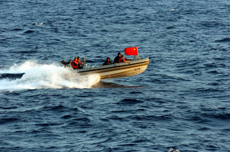 Chinese navy special forces members of &apos;Zhoushan&apos; missile frigate prepare to patrol by a speed boat at sea, October 23, 2009.