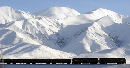 A train runs at the foot of snow-covered mountains in northwest China&apos;s Qinghai Province, October 24, 2009. The Qinghai-Tibet railway will enter its 4th winter operation after three year&apos;s safety running, which strongly boosted the economic and social developments in Qinghai and Tibet Autonomous Region.