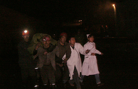 Medics and succors evacuate the wounded miners from the Yongxing Gaozhuang coal mine in Shenmu County of northwest China's Shaanxi Province, October 25, 2009. 