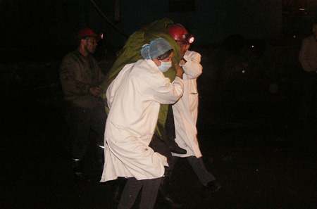 Medics and succors evacuate the wounded miners from the Yongxing Gaozhuang coal mine in Shenmu County of northwest China's Shaanxi Province, October 25, 2009.