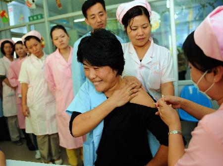 A medical worker receives a H1N1 influenza vaccination at a community heath care center in Fuzhou, southwest China's Fujian province, October 26, 2009.