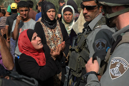 Palestinian woman shouts at Israeli soldiers after several Palestinian farmers clash with Israeli settlers in the West Bank city of Nablus, October 27, 2009. 