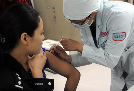 A policewoman receives the A/H1N1 influenza vaccination at a hospital in Shijiazhuang, capital of north China's Hebei Province, on October 28, 2009.