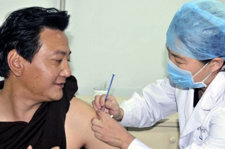 A man gets the A/H1N1 influenza vaccination from medical staff with local center for disease control and prevention, at Xingtai City, north China's Hebei Province, October 27, 2009. 