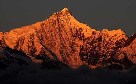 The Kawagebo Peak of Meili Snow Mountain is illuminated by sunlight in Deqin county, Diqing Tibetan Autonomous Prefecture, in southwest China's Yunnan province, on October 27, 2009. 