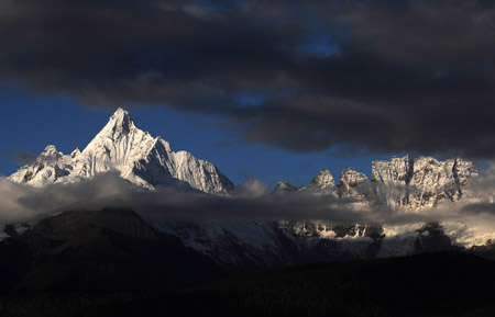 The village at the foot of Meili Snow Mountain is illuminated by sunlight in Deqin county, Diqing Tibetan Autonomous Prefecture, in southwest China's Yunnan Province, on October 27, 2009. 