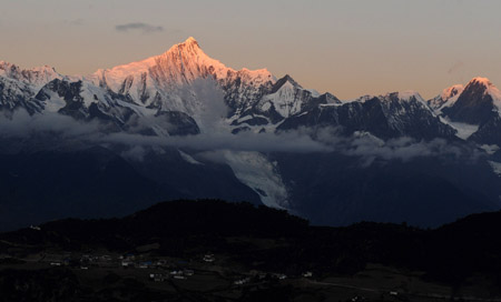 The Kawagebo Peak of Meili Snow Mountain is illuminated by sunrise in Deqin county, Diqing Tibetan Autonomous Prefecture, in southwest China's Yunnan Province, on October 27, 2009.