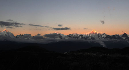 The Meili Snow Mountain is illuminated by sunrise in Deqin county, Diqing Tibetan Autonomous Prefecture, in southwest China's Yunnan Province, on October 27, 2009. 