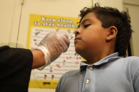 A student receives a free H1N1 flu vaccine at the 157 Public Elementary School in New York, the United States, October 28, 2009. New York City began its school-based H1N1 influenza vaccination campaign on Wednesday. The first phase of the three-stage initiative started at 125 schools with enrollment of less than 400.